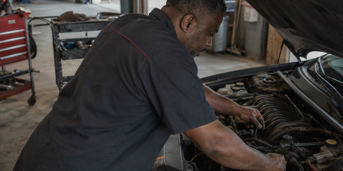 Mechanic working under the hood at a tire and auto shop